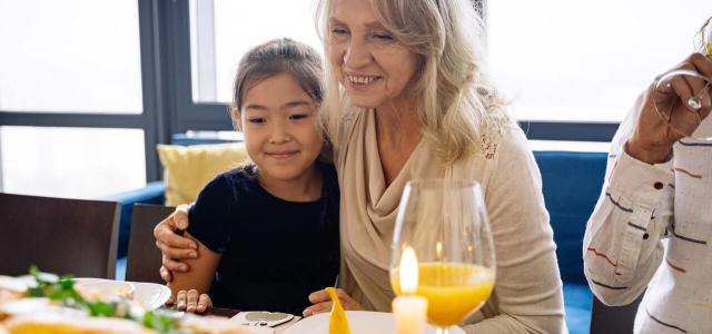 Women sitting with her arm around a young girl smiling